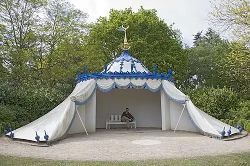 A colour photograph of a white tent decorated with blue fringing and topped with a gold-coloured crescent