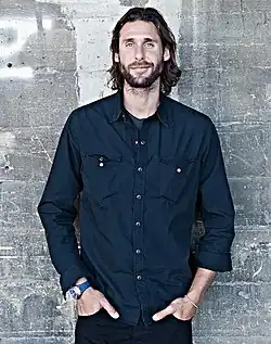 Rothschild in business casual clothes against a grunge background
