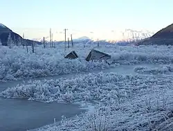 An image of a broken down house in the snow