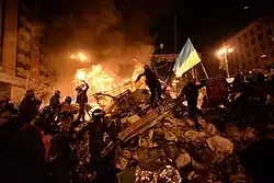 State flag of Ukraine behind a wall of anonymous protesters in Kyiv, Ukraine. Events of February 18, 2014