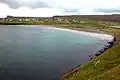 The inlet Sandsvágur and the sandy beach after which the village is called. This is the only beach on the Faroe Islands with dunes and beach grass.