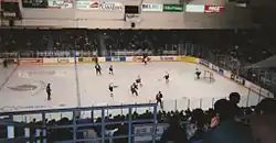 men on skates playing ice hockey in an arena