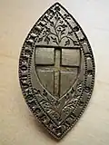 14th-century brass stamp with the shield insignia.