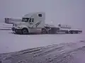 Freightliner Columbia with single drop flatbed (also known as a stepdeck) trailer