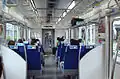Interior of a 50090 series EMU on a TJ Liner service, showing forward-facing transverse seating configuration