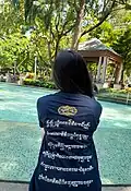A woman wearing a t-shirt with Aksara Kawi