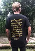 A man wearing a t-shirt with Aksara Kawi