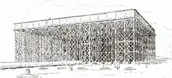 black and white drawing of a square tank, not very deep compared to its very large area, elevated high on trestles, with a pipe on the ground larger than the people in the foreground
