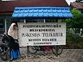 A nameplate for a public health center protected with a cungkup at Teluk Bayur, Berau