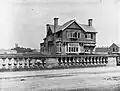 a monochrome photo of a building from a bridge with short stone pillers
