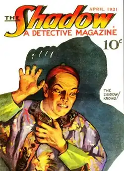 A man in Chinese dress raising a hand threateningly, casting a dark shadow behind him