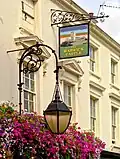 Scrolled iron lamp and sign brackets mentioned by Historic England[3]