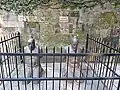 The present statues, beneath a 'No Spitting' sign
