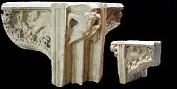 Limestone carving of a medieval sculpture depicting a grotesque figure holding onto the corner edge of the stone.