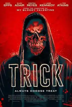 A hooded teen wears a Halloween skull mask.
