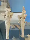 Photograph of two ceramic figurines with breasts arms and incised eyes