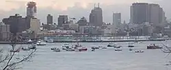 Boats surround the tail of the sunken plane, visible just above the water line