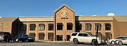 A two-story office building with a prominent CBS eye sign and satellite dishes on the roof.