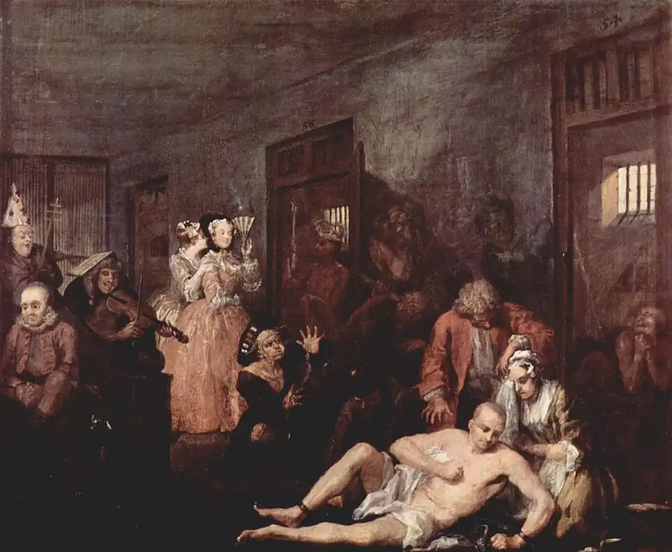 A 1735 oil version of the last scene from William Hogarth's A Rake's Progress, the story of a rich merchant's son, Tom Rakewell, whose immoral living causes him to end up in Bethlem. A shaven-head and near-naked Rakewell is depicted in one of galleries of Bethlem. He sits on the floor while his right leg is being manacled by an attendant. A wigged doctor is standing over him. Rakewell's spurned fiancée kneels beside him, crying. Inmates exhibiting various stereotypical forms of madness are shown in their open cells and in the corridor. Two fashionably dressed lady-visitors standing by the cell of a "urinating mad monarch", are clearly amused by the show. One holds a fan up to her face and is clearly smiling while her companion whispers in ear. Hogarth became a governor of Bethlem in 1752.