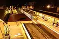 Eastbound view of Platform 2 with an X'Trapolis train arriving at Platform 1 on a City-bound service at night, August 2018